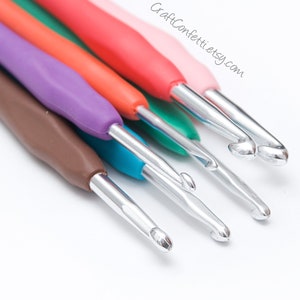 May include: A set of six colorful crochet hooks with silver metal hooks. The hooks are arranged in a row, with the largest hook at the top and the smallest hook at the bottom. The hooks are made of plastic and have a smooth, comfortable grip.
