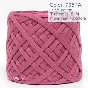 May include: A close-up of a pink ball of yarn, made from 95% cotton. The yarn is woven in a criss-cross pattern. The label reads "Color: 735PA", "Thickness: S, M", and "more than 40 colours".