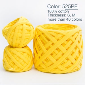 Puede incluir: Tres ovillos de hilo amarillo, uno grande y dos más pequeños, hechos de 100% algodón. El hilo es de estilo grueso y está disponible en más de 40 colores. El hilo está etiquetado como "525PE".