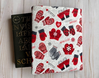 May include: A white book cover with a red and gray mitten pattern. The text "I love winter" and "Cold hands warm heart" are repeated on the cover.