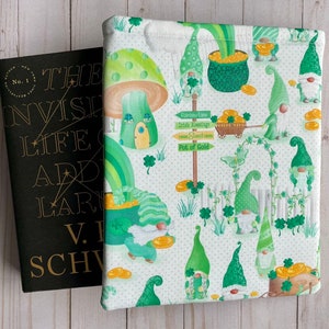 May include: A white book cover with a green and gold pattern of gnomes, mushrooms, rainbows, and shamrocks. The text "Rainbow Lane", "Irish Greetings", "Sweet Corn", and "Pot of Gold" is on a signpost.