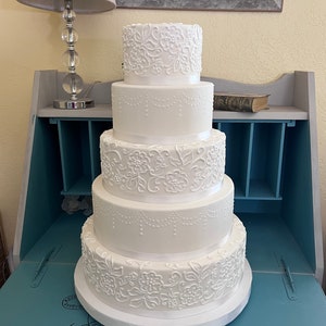 Five tier lace and swag faux wedding cake