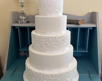 Five tier lace and swag faux wedding cake