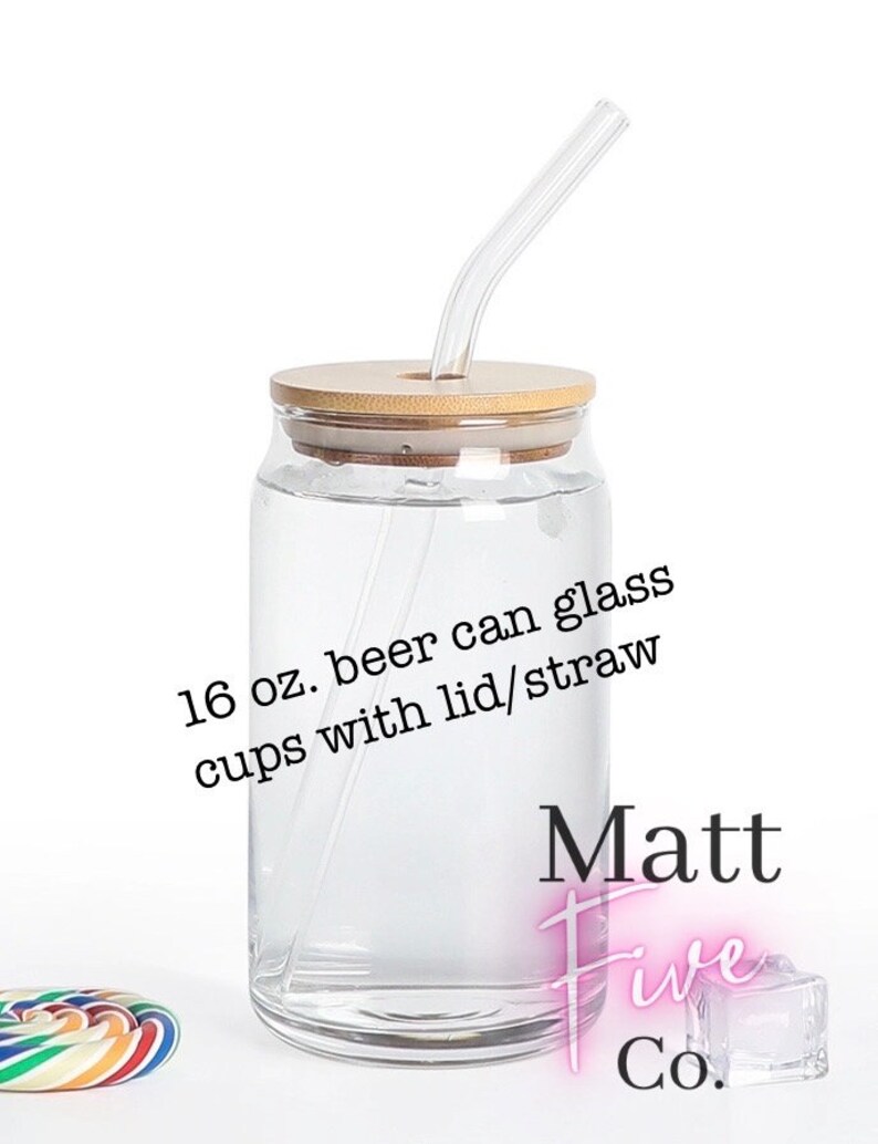 May include: A clear glass beer can cup with a bamboo lid and a clear straw. The cup is labeled "16 oz. beer can glass cups with lid/straw". The cup is on a white background.