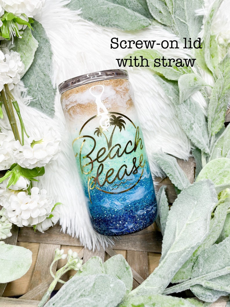 May include: A stainless steel tumbler with a screw-on lid and straw. The tumbler features a beach-themed design with gold lettering that says "Beach please". The design includes shades of blue, white, and gold glitter.