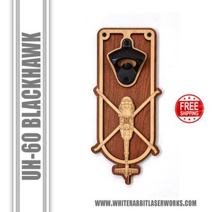 May include: Wooden bottle opener with a black metal bottle opener and a laser engraved image of a UH-60 Blackhawk helicopter. The bottle opener is on a wooden background.
