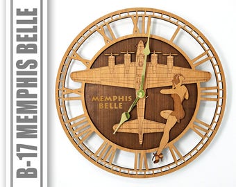 May include: A wooden clock featuring a B-17 bomber plane with the text "Memphis Belle" on the face. The clock has a brown wood background and gold-colored hands.