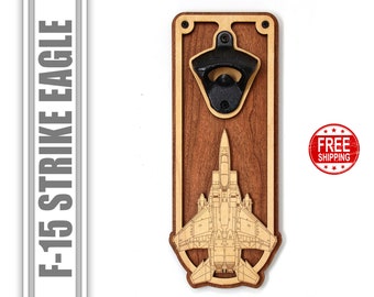 Könnte beinhalten: Wandmontierter Flaschenöffner aus Holz mit einem lasergravierten F-15 Strike Eagle Jet-Design. Der Flaschenöffner hat einen schwarzen Flaschenöffner aus Metall.