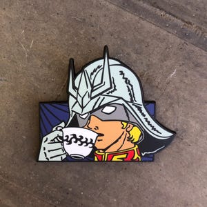 May include: A blue, red, and yellow enamel pin of a character wearing a white helmet with a blue and white cup in their hand. The character is drinking from the cup. The background is a dark blue and purple.