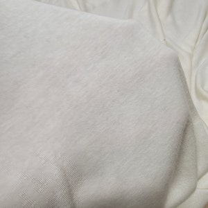 以下が含まれることがあります： 滑らかな質感の白い布のシート。シートは折り畳まれており、わずかに光沢があります。