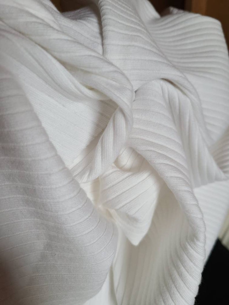 May include: Close-up of white ribbed fabric, showing the texture and folds of the material.