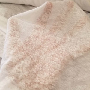 Puede incluir: Tela blanca transparente con una superficie texturizada ligeramente rugosa. La tela es ligera y tiene un brillo sutil.