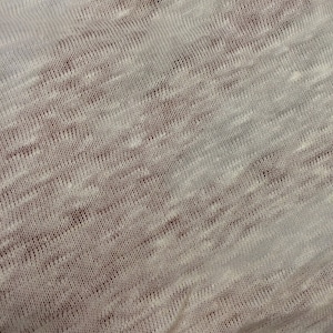 Op de afbeelding: Close-up van een witte gebreide stof met een subtiel textuurpatroon.