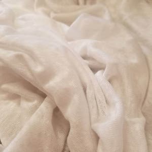 Puede incluir: Tela blanca con una superficie suave y texturizada. La tela est&aacute; arrugada y doblada, creando una sensaci&oacute;n de profundidad y dimensi&oacute;n.