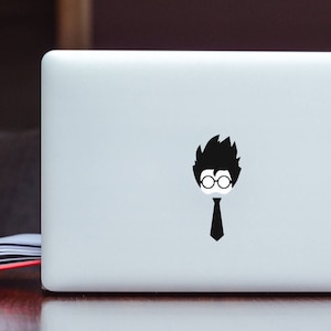 Puede incluir: Una pegatina en blanco y negro de un personaje de dibujos animados con gafas y corbata en un portátil plateado.