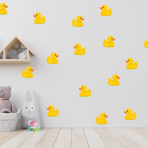 May include: A white wall with a yellow rubber ducky pattern. The ducks are arranged in a repeating pattern. There is a wooden shelf with a stuffed animal on it.