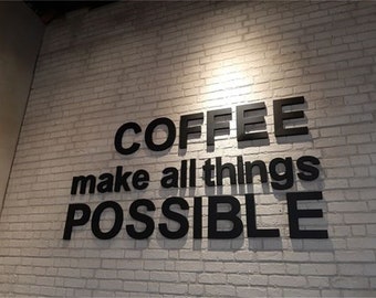 May include: Black and white sign on a white brick wall that reads "COFFEE make all things POSSIBLE".