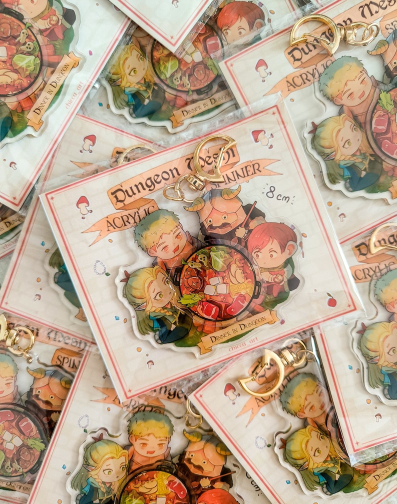 May include: A set of four acrylic keychains featuring characters from a fantasy game. The keychains are 8 cm in diameter and depict a group of adventurers enjoying a meal together. The keychains are packaged in a clear plastic bag with a white background and the text "Dungeon Design Acrylic Inner" printed on it.