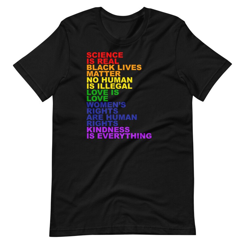 May include: Black t-shirt with a rainbow-colored message that reads "Science is real, Black Lives Matter, No Human is Illegal, Love is Love, Women's Rights are Human Rights, Kindness is Everything."