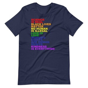May include: Navy blue t-shirt with a rainbow-colored message that reads "Science is real, Black Lives Matter, No human is illegal, Love is love, Women's rights are human rights, Kindness is everything."