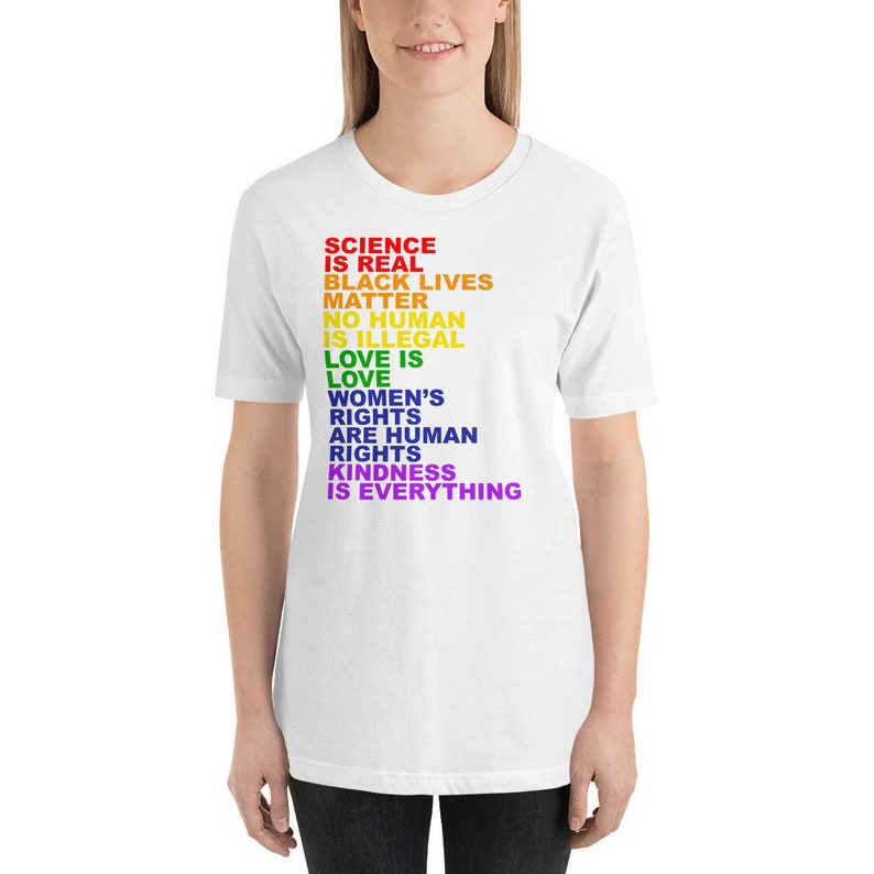 May include: White t-shirt with a rainbow-colored message that reads "Science is real, Black lives matter, No human is illegal, Love is love, Women's rights are human rights, Kindness is everything."