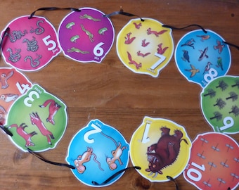 May include: A colorful string of ten round cards with numbers one through ten. Each card features a different animal and the number written out. The animals include a monster, owls, mice, foxes, frogs, squirrels, birds, trees, and dragonflies.