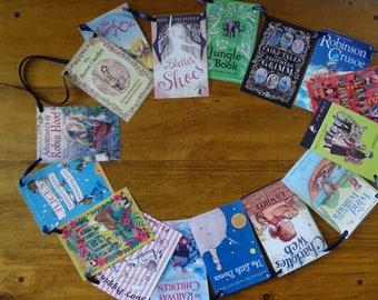 Könnte beinhalten: Eine Girlande aus Buchumschlägen mit klassischen Kinderbuchtiteln, darunter "Der geheime Garten", "Die Abenteuer von Robin Hood", "Alice im Wunderland", "Mary Poppins", "Die Kinder der Eisenbahnbauarbeiter", "Der kleine Prinz", "Charlotte's Web", "Der Wind in den Weiden", "Robinson Crusoe", "Märchen der Brüder Grimm", "Dschungelbuch", "Ballett-Schuhe" und "Der Zauberer von Oz".