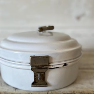 May include: White enamel bread box with a metal latch and a handle on the top.