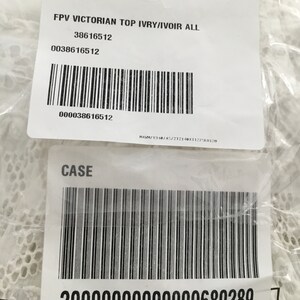May include: Two white product labels with black text and barcodes. The top label reads "FPV VICTORIAN TOP IVRY/IVOIR ALL" and includes a product number. The bottom label reads "CASE" and has a long barcode with a product number.