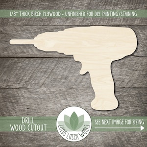 May include: Unfinished wood cutout of a drill, 1/8 inch thick birch plywood. The cutout is on a wood background. The text "DRILL WOOD CUTOUT" is at the bottom of the image. The text "SEE NEXT IMAGE FOR SIZING" is at the bottom right of the image. The text "LOTUS LASER WORKS" is in a circle with a green lotus flower design.