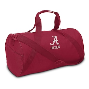 May include: Crimson red duffel bag with a white embroidered "A" and the word "HUDSON" underneath.