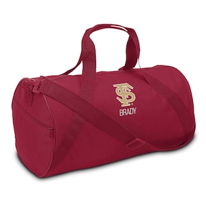 May include: A red duffel bag with a gold embroidered logo and the name "BRADY" on it.