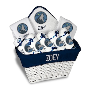 May include: A white wicker basket filled with white towels and washcloths, all featuring a howling wolf design in a blue circle. The name "ZOEY" is printed on the towels and the basket's trim. The basket has a navy blue trim.