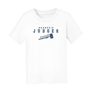 May include: White t-shirt featuring the text "BRANDEIS JUDGES" in navy blue, with a gavel graphic. The shirt is a short-sleeved crew neck.
