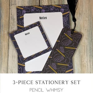 May include: A 3-piece stationery set with a pencil-themed design. The set includes a notepad, a smaller notepad, and a bookmark. The items have a dark background with yellow pencils and purple scribbles. The notepad and smaller notepad have the word "Notes" printed on them.