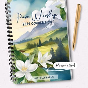 May include: A spiral bound notebook with a watercolor illustration of a mountain range, flowers, and a river. The text "Pure Worship 2025 Convention" is printed on the cover. The text "Personalize!" is written in a white box on the bottom right corner of the cover. The text "Michelle Barns" is printed on the bottom left corner of the cover.