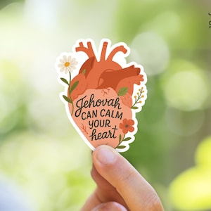 May include: A sticker with a heart-shaped design featuring a stylised anatomical heart with floral accents. The text "Jehovah can calm your heart" is written in a stylised font.