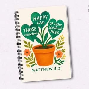 May include: Spiral-bound notebook with a cream-colored cover featuring a hand-painted illustration. The artwork depicts a plant with green heart-shaped leaves, orange flowers, and the text "HAPPY are THOSE conscious OF THEIR spiritual NEED" and "MATTHEW 5:3".