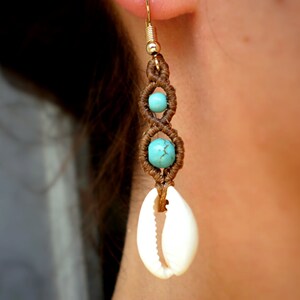May include: Brown macrame earrings with turquoise beads and a white shell charm.