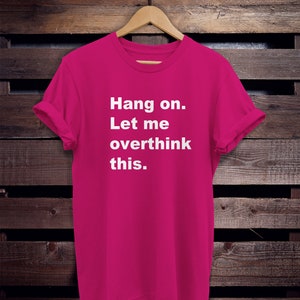 May include: A pink t-shirt with the text "Hang on. Let me overthink this." printed in white.
