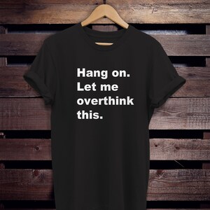 May include: Black t-shirt with white text that reads "Hang on. Let me overthink this."