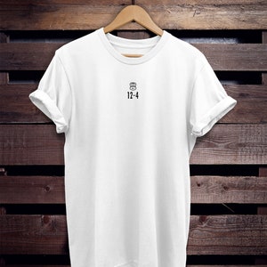 May include: White t-shirt with a black chef hat icon and the text "12-4" printed on the front.