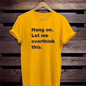 May include: Yellow t-shirt with black text that reads "Hang on. Let me overthink this."