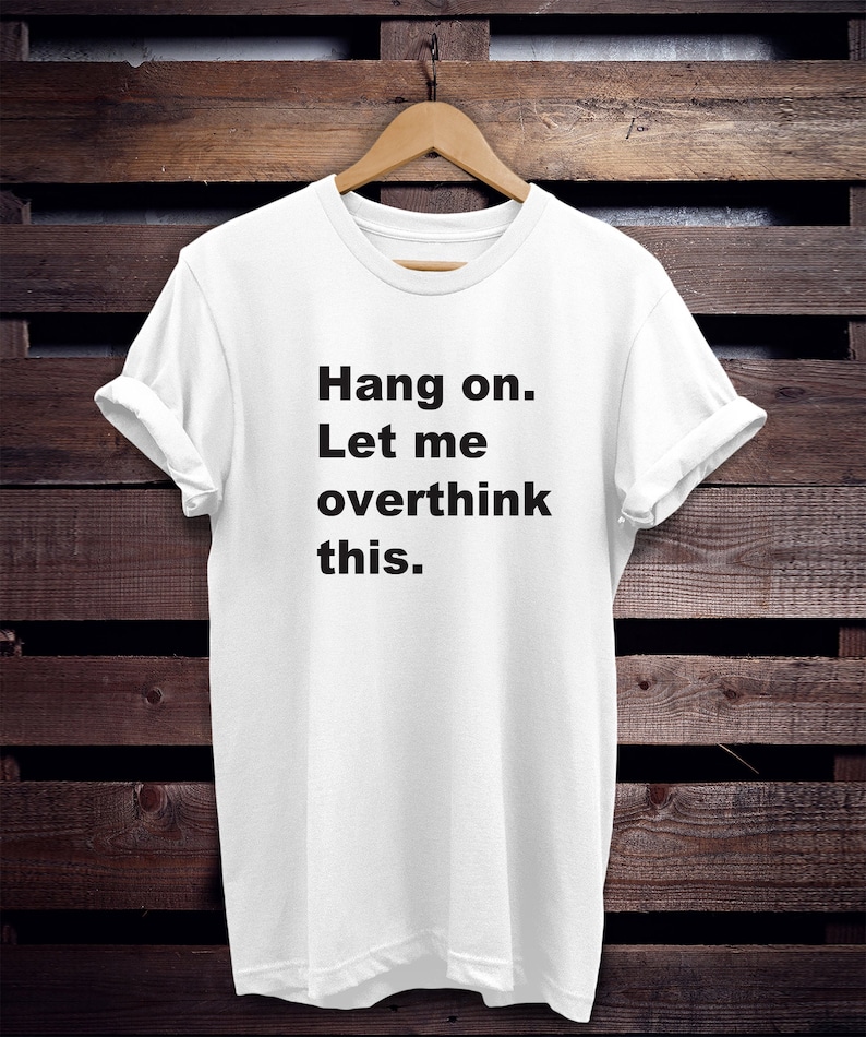 May include: White t-shirt with black text that reads "Hang on. Let me overthink this."