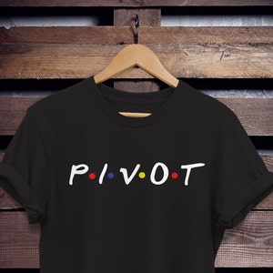 Könnte beinhalten: Schwarzes T-Shirt mit dem Wort "PIVOT" in weißen Buchstaben und bunten Punkten, inspiriert von der beliebten Fernsehserie "Friends".
