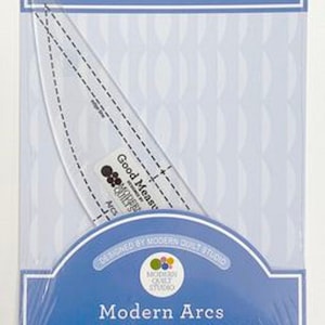 May include: A clear plastic Good Measure cutting template for quilting, packaged in a blue and white card. The template is curved with dashed lines for measurement. The package reads "Modern Arcs".
