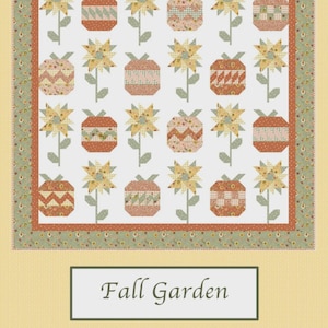 Może przedstawiać: Kołdra z kwiatowym wzorem z słonecznikami i geometrycznymi kształtami w odcieniach pomarańczu, żółci i zieleni. Kołdra zatytułowana "Fall Garden" i "Sew-N-Quilt" autorstwa LaVonne Jackson.