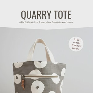 May include: A gray tote bag with white circular patterns and a matching orange zippered pouch. The tote has a cream-colored handle and a front zipper. The text "QUARRY TOTE" and "noodlehead" are visible.