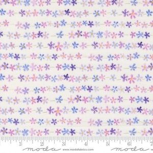 May include: Fabric with a repeating floral pattern. The design features rows of small flowers in shades of purple, lavender, and blue, connected by thin green stems, set against a cream background. The fabric has a ruler printed along the bottom edge.