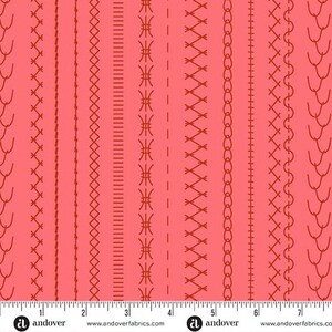 Pode incluir: Um tecido rosa coral com um padrão repetitivo de vários designs de pontos de costura em vermelho escuro dispostos em colunas verticais. Uma fita métrica branca é visível na borda inferior, mostrando uma escala de 7 polegadas com o texto andover.
